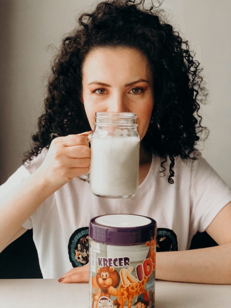 ¿Los envío al colegio, sí o no? Mujer tomando una malteada nutritiva